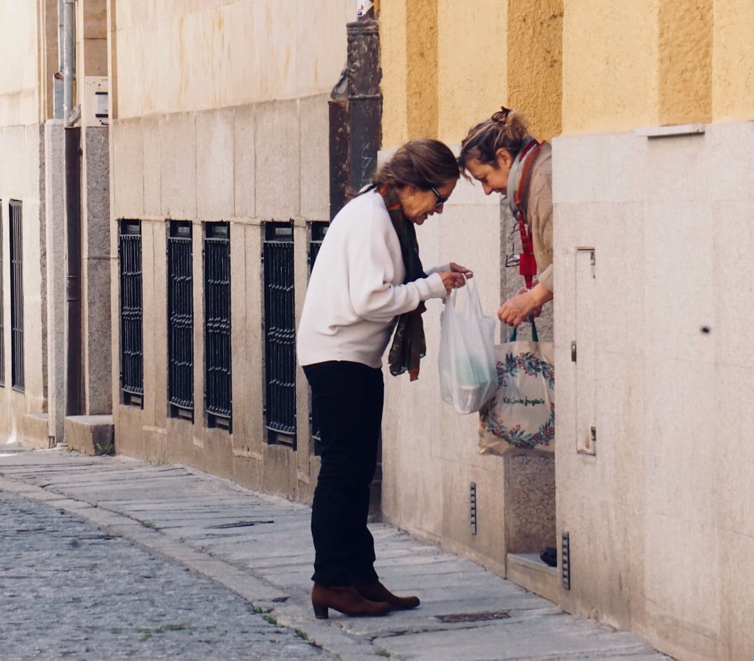 Young volunteer helping an elderly woman with groceries