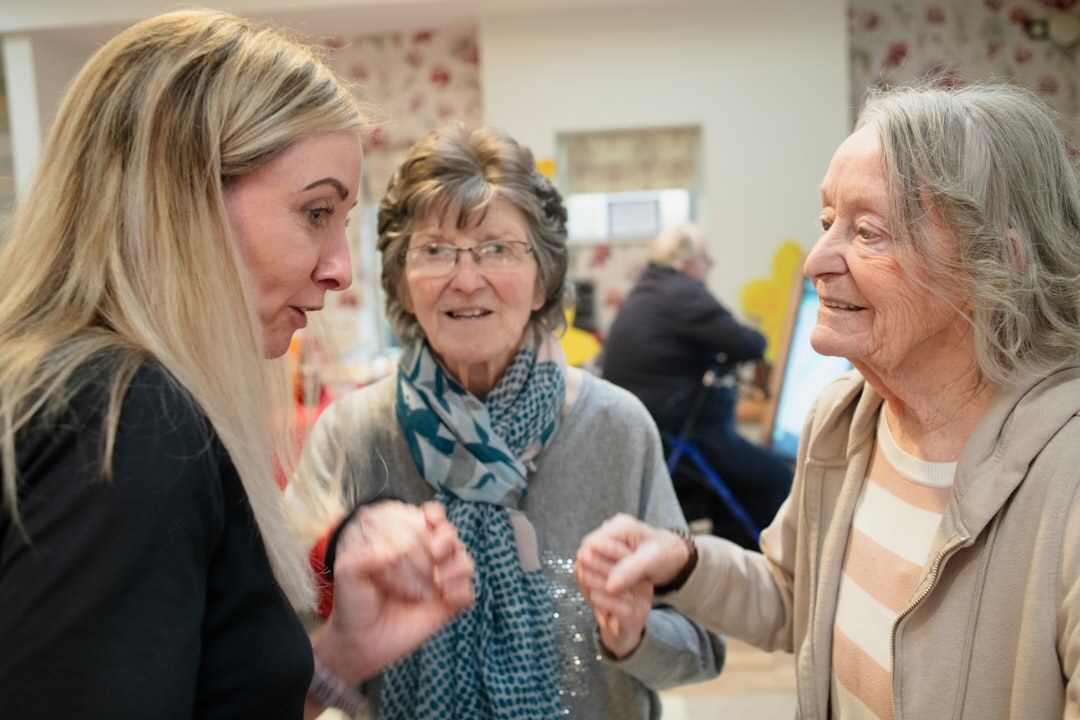 Group of smiling seniors sitting together around a table at a community center