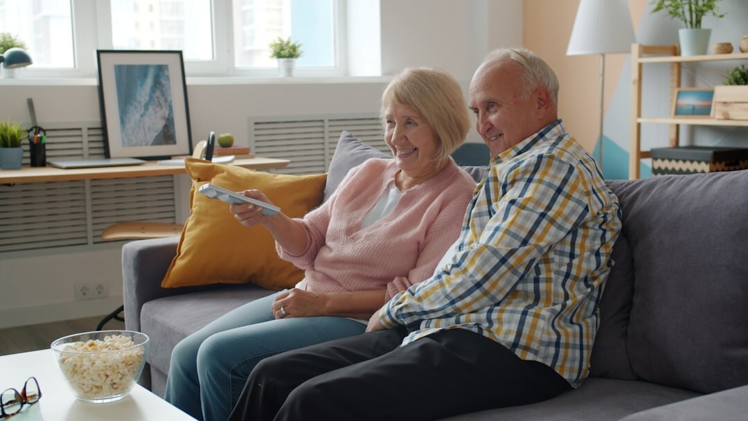 Seniors sitting together watching a film in a cozy lounge